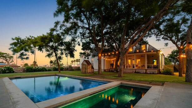 Une piscine rectangulaire dotée d’un éclairage vert, entourée d’une terrasse en béton.