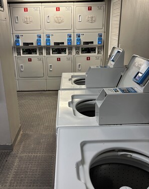 A laundry facility with multiple washing machines and dryers, each marked with a number.