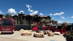 En rød varevogn parkeret foran en bygning med skiltet 'Park City Canyons Village'.