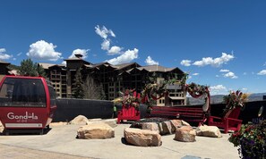 Un furgone rosso parcheggiato di fronte a un edificio con un cartello che riporta 'Park City Canyons Village'.