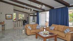 A spacious living room with a beige sofa set, a wooden coffee table, and a kitchen area in the background. - A Charming Spanish Villa, Just Perfect for your Mijas Vacation (Mijas)