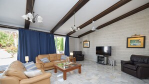 A living room with a fireplace, leather sofas, a TV, and a marble floor. - A Charming Spanish Villa, Just Perfect for your Mijas Vacation (Mijas)