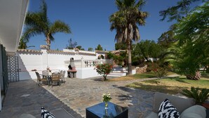 An outdoor patio with stone flooring, a glass-top table, and a sofa with patterned cushions. - A Charming Spanish Villa, Just Perfect for your Mijas Vacation (Mijas)