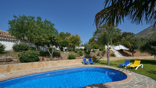 A swimming pool with a stone border, surrounded by a stone patio and two lounge chairs. - A Charming Spanish Villa, Just Perfect for your Mijas Vacation (Mijas)