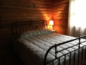 Cozy retreat with a single bed, bedside table, and lamp, set against a backdrop of horizontal panels.