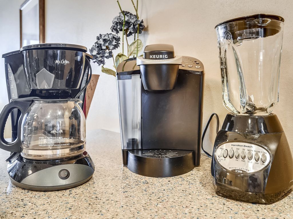 Eine Kaffeemaschine, eine Keurig-Kaffeepadmaschine und ein Hamilton Beach-Mixer auf einer Küchenarbeitsplatte.