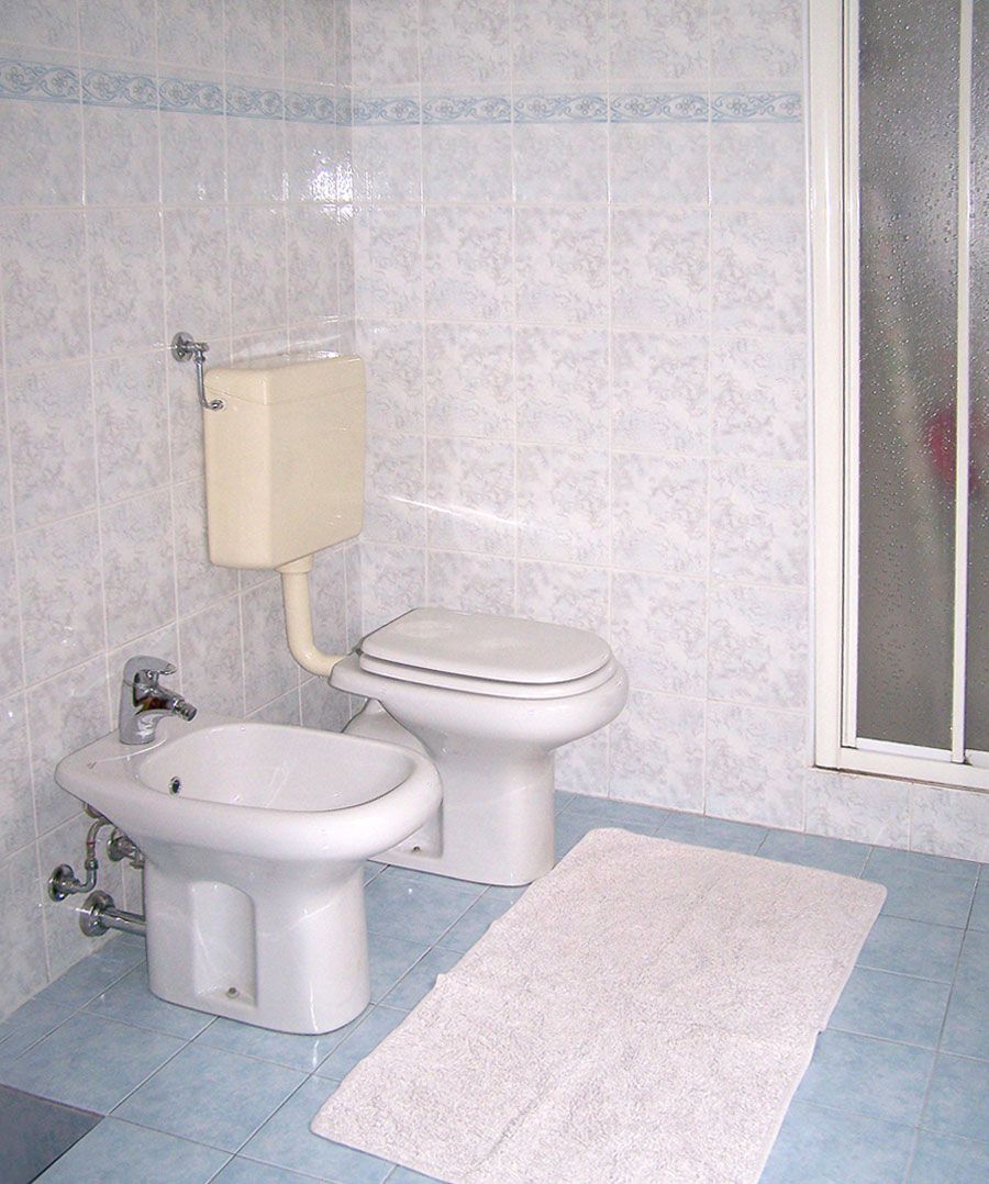 A bathroom with a toilet, bidet, and sink.
