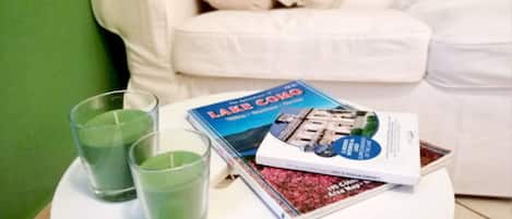 A white table with a book titled "Lake Como" and two glasses of green liquid.