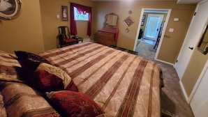 A bedroom with a large bed, a ceiling fan, a dresser, and a chair. - Cozy guest apartment conveniently located to all Woodland Park attractions (Woodland Park)