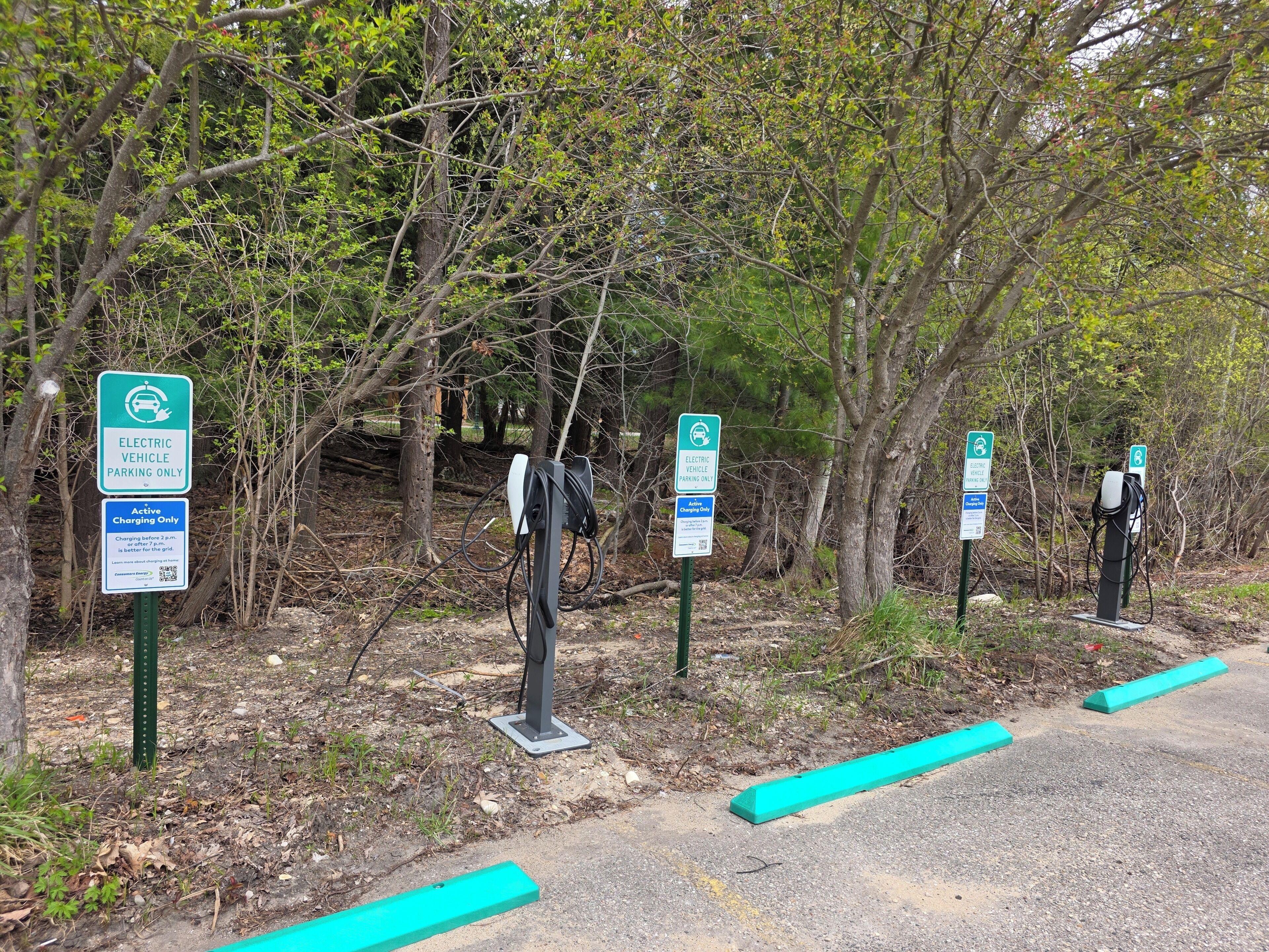 Electric vehicle charging stations with signs indicating 'ELECTRIC VEHICLE PARKING ONLY' and 'Active Charging Only.'
