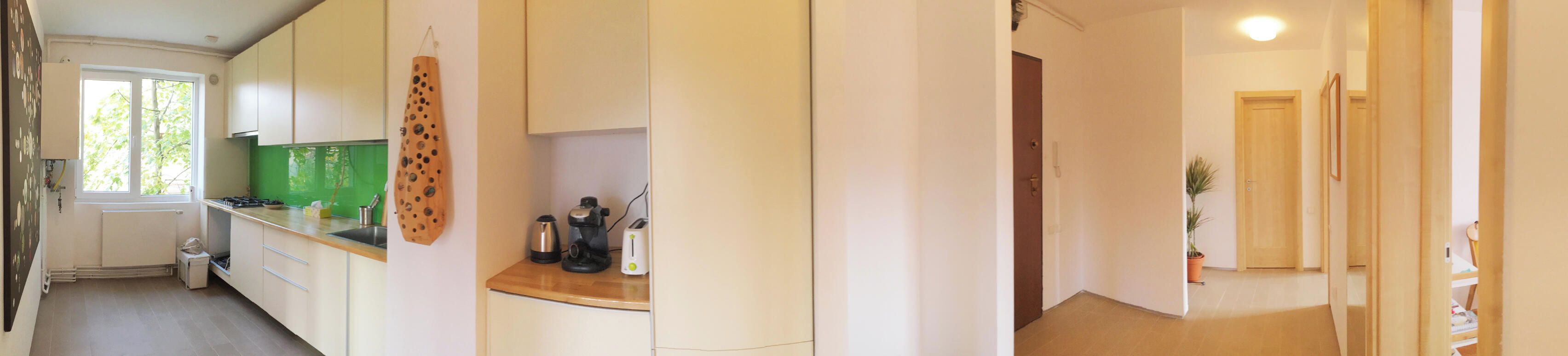A kitchen with a window, a green backsplash, and a wooden countertop.