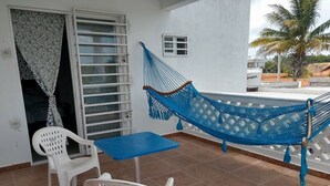 A balcony with a blue hammock, white plastic chairs, and a small table. - **New Listing**  Close to the Sea, 2 blocks from the Beach (Chicxulub Puerto)