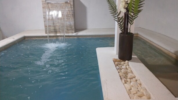A small indoor pool with a waterfall feature and decorative plants. - **New Listing**  Close to the Sea, 2 blocks from the Beach (Chicxulub Puerto)