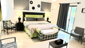 A modern bedroom with a bed, two chairs, a small table, and a ceiling fan. - **New Listing**  Close to the Sea, 2 blocks from the Beach (Chicxulub Puerto)