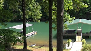 A serene outdoor area with a hammock, a small garden bed, and a pathway leading to a dock. - Quiet cove, deep water, minutes to Clemson, pet friendly, easy path to the dock (Seneca)