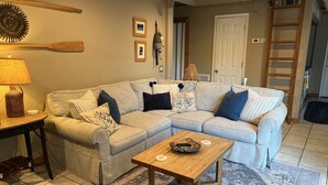 A living room with a grey sectional sofa, a wooden coffee table, a patterned rug, and a lamp on a side table. - Quiet cove, deep water, minutes to Clemson, pet friendly, easy path to the dock (Seneca)