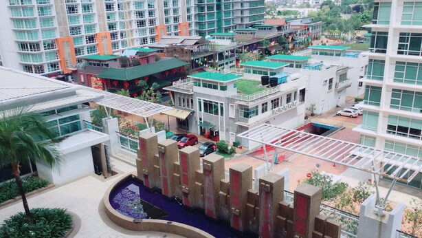 Um complexo residencial com vários edifícios, um pátio central com piscina e um passeio para pedestres.
