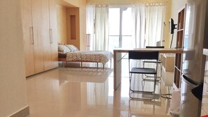 Quarto amplo com cama, escrivaninha e cadeira.