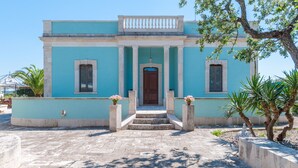A building with a blue facade, a central entrance with steps, and columns. - Spacious Villa with Pool in Puglia for 8 people  (Putignano)