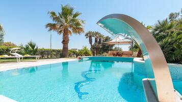 Alberca al aire libre y camastros