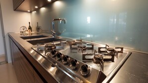 A modern kitchen with stainless steel appliances, a double sink, and a gas range. - Spacious Villa with Pool in Puglia for 8 people  (Putignano)