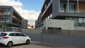 Um edifício moderno com vários andares, janelas amplas e uma área de varanda.