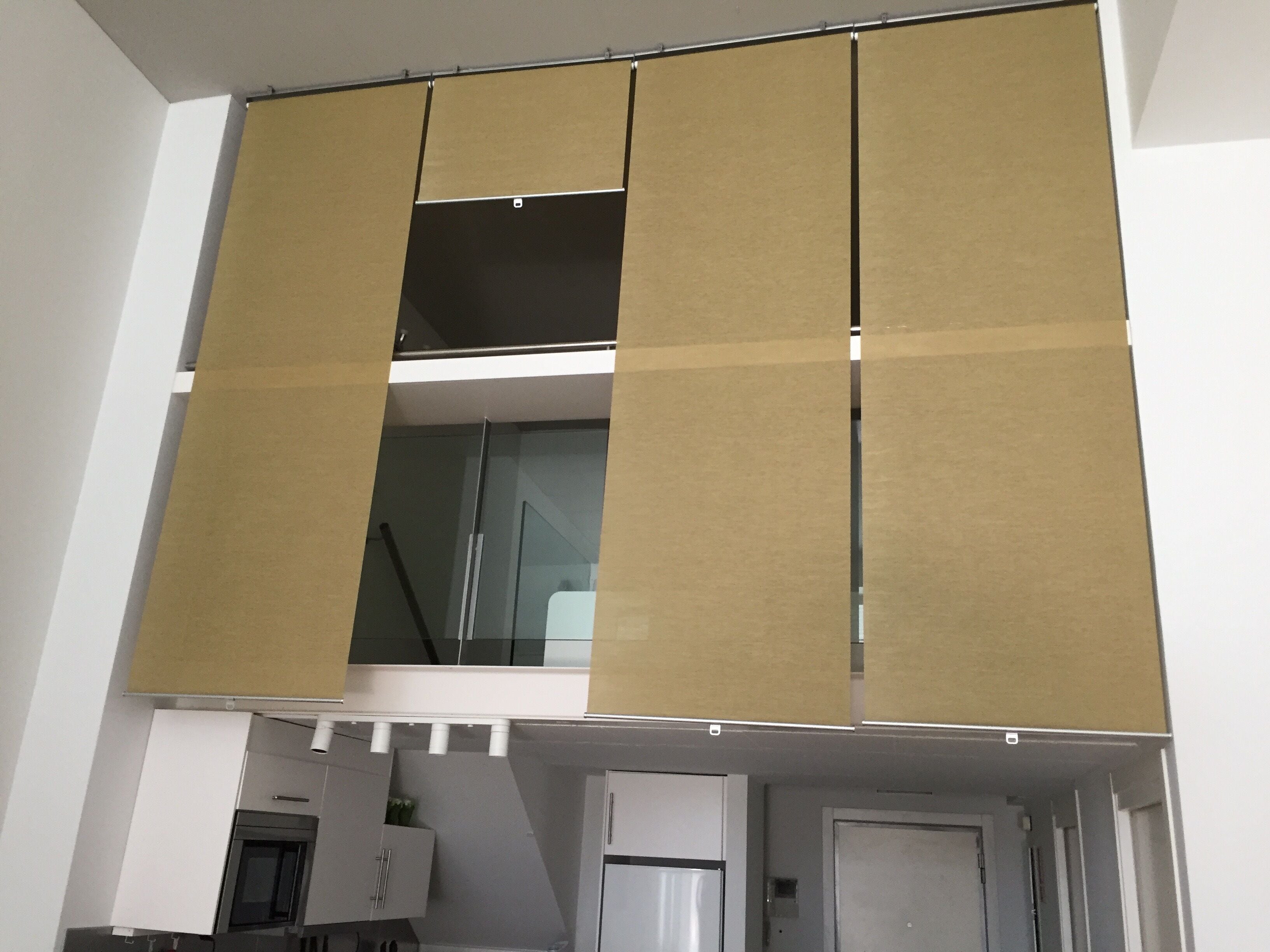 Una habitación con pared divisoria corrediza, microondas, refrigerador y puerta.
