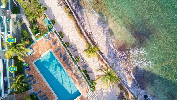 An aerial view of a resort with a swimming pool, beach, and palm trees. - Playa Linda - St. Thomas Oceanfront Studio Condo at Pool & Bolongo Beach, USVI (St. Thomas)