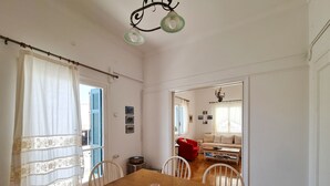 A dining area with a wooden table, white chairs, and a tray with drinks. - My Home in Naxos Town With Sea View (Naxos)