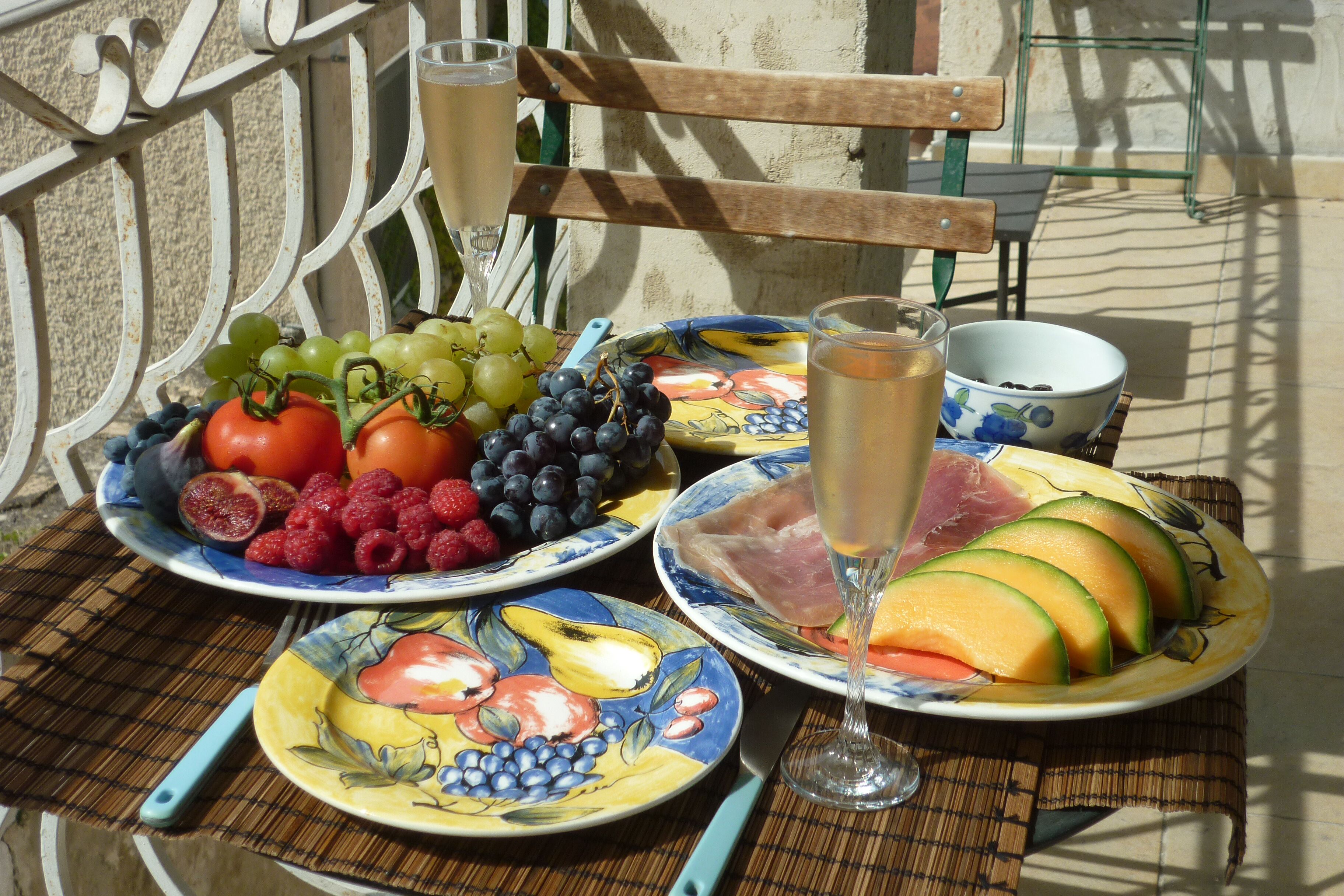 Een tafel met fruit, een glas drinken en een schaal.