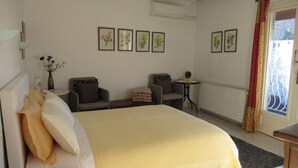 A hotel room with a bed, two armchairs, a small table, and a radiator. - Air-conditioned & heated cottage in picturesque Pernes-les-Fontaines (Pernes-les-Fontaines)