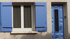 A building with a window and a door, both with blue shutters. - Air-conditioned & heated cottage in picturesque Pernes-les-Fontaines (Pernes-les-Fontaines)