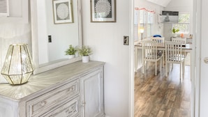 Un intérieur aux couleurs claires, avec une table à manger en bois, des chaises et un meuble avec des tiroirs.