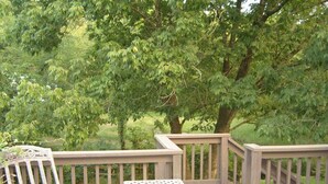 A wooden deck with a table and two chairs, surrounded by lush green trees. - Musician's Haven in Music City - 7 miles to downtown - off-street parking (Nashville)