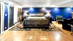 A modern bedroom with a bed, two bedside lamps, a chair, and a small table. - Musician's Haven in Music City - 7 miles to downtown - off-street parking (Nashville)