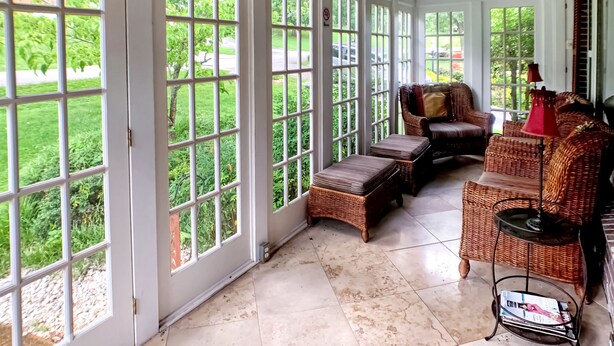 A sunroom with large windows, wicker furniture, and a ceiling fan. - Musician's Haven in Music City - 7 miles to downtown - off-street parking (Nashville)
