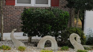 A garden with a brick wall, a tree, and a statue of a creature. - Musician's Haven in Music City - 7 miles to downtown - off-street parking (Nashville)