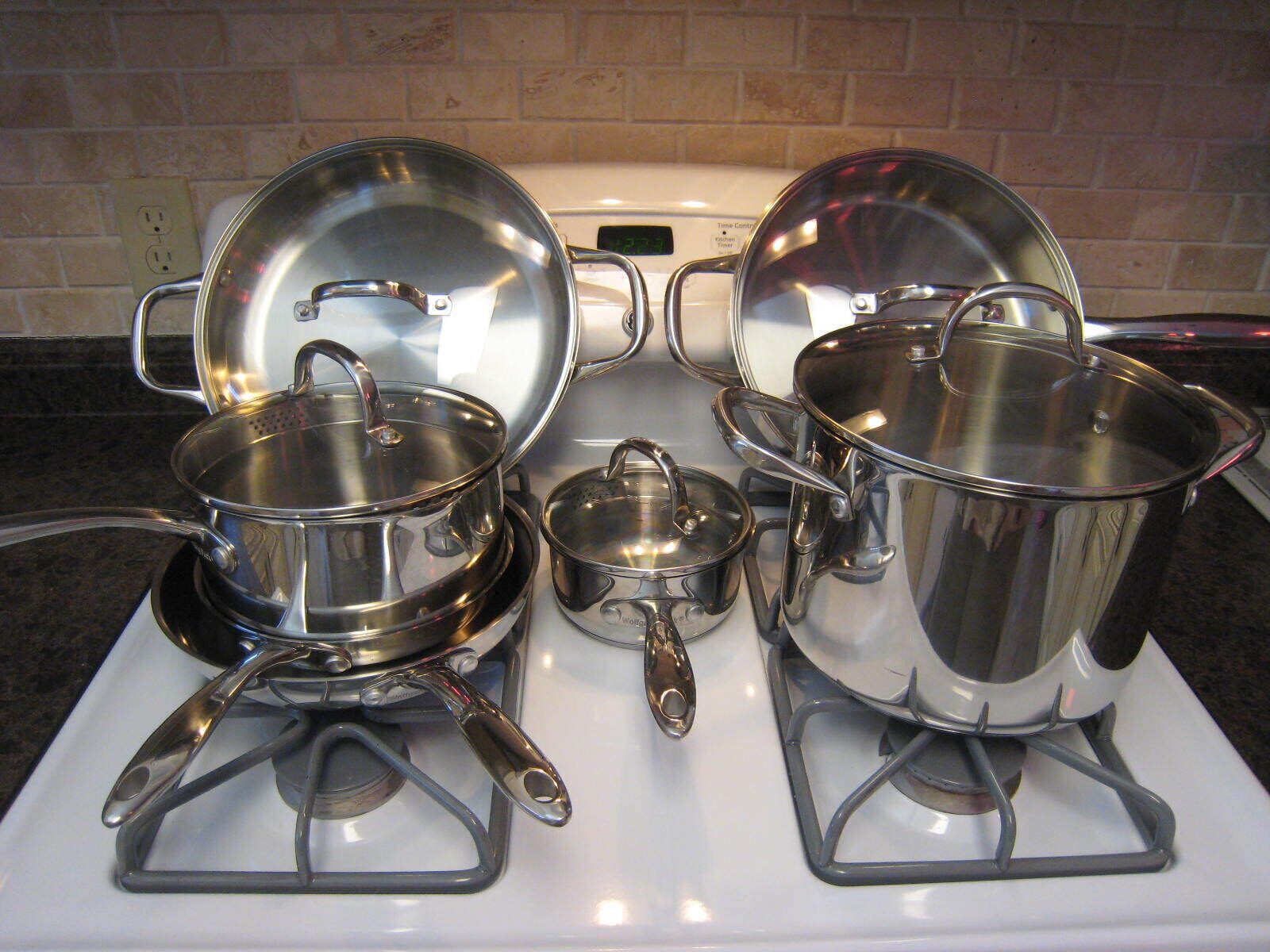 Une cuisine avec des ustensiles de cuisine en acier inoxydable sur une cuisinière.