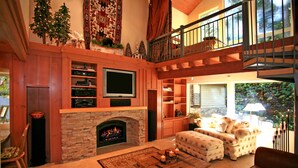 Un salón espacioso con chimenea, televisión y una zona de estar acogedora.