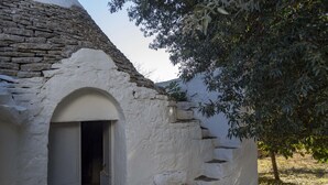 Ein rustikales Steinhaus mit weißer Fassade und einem Hauseingang.