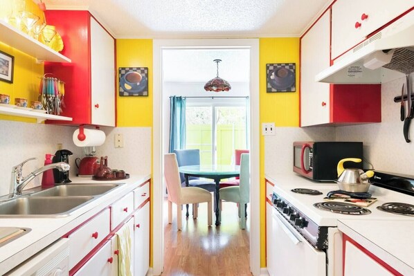 Una cocina estrecha con una zona de comedor en el centro, que incluye una mesa y sillas.