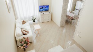 Uma sala de estar moderna com um sofá, uma mesa de centro e uma TV sobre um aparador.
