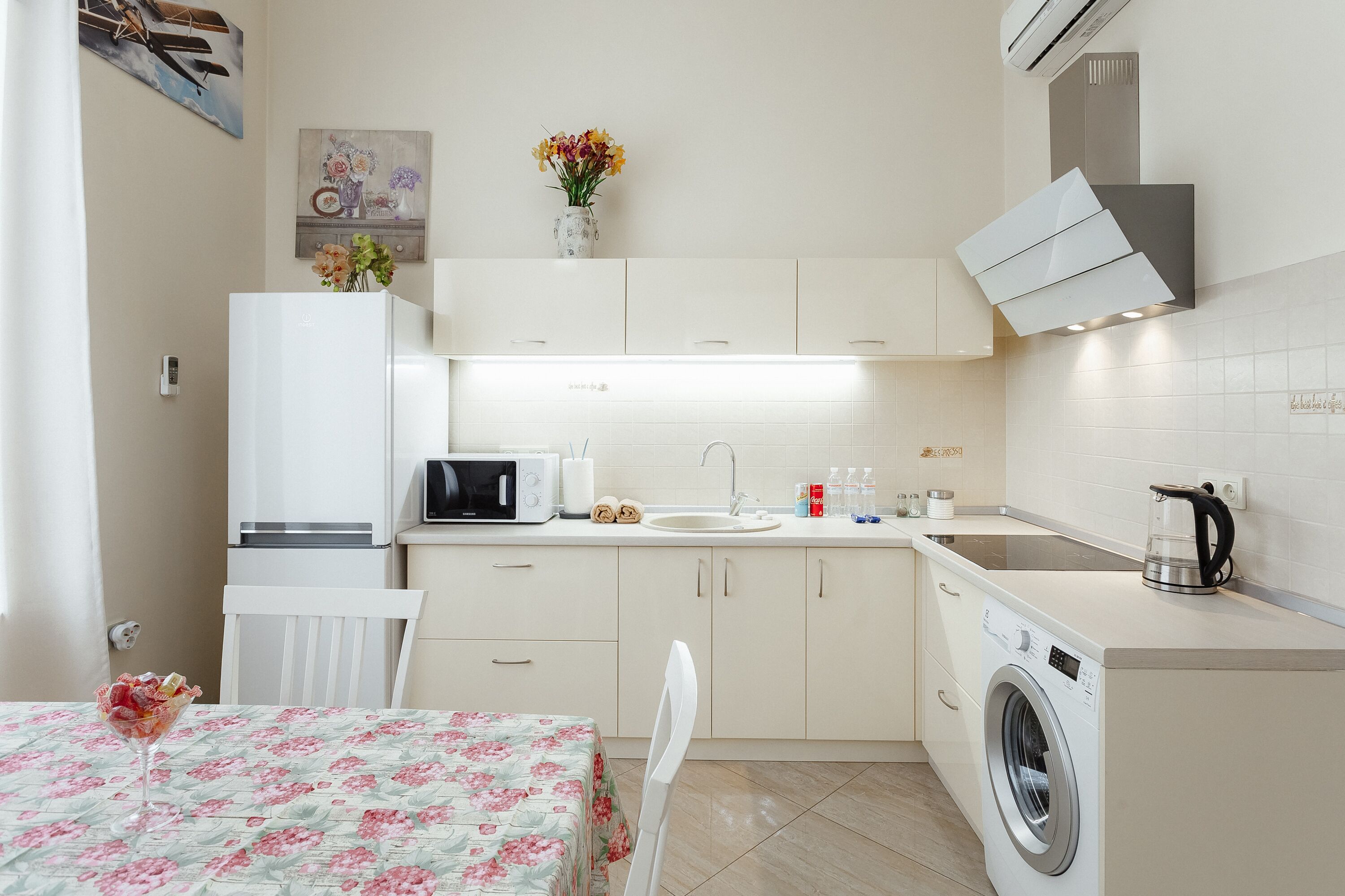 A compact kitchen with a microwave, sink, and a built-in washing machine.