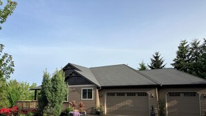 A two-story house with a dark brown exterior, a sloped roof, and a garage with two doors. - Spacious Single Party B&B – walking distance to downtown!  (Dundee)