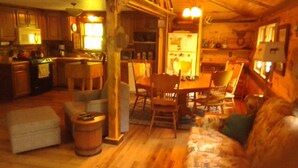 Un acogedor interior de cabaña con comedor, cocina y zona de estar.