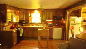 Una cocina con gabinetes de madera, una estufa, un fregadero y un lavavajillas.
