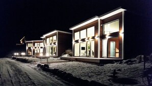 Moderni rakennus, jossa on useita ikkunoita ja lumipeitteinen maa.
