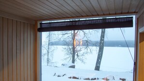 Huone, jossa on suuri ikkuna, josta avautuu näkymä lumiseen maisemaan.