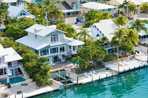 A coastal residential area with multiple houses, a swimming pool, and a dock. - Ocean Front Modern Home (Summerland Key)
