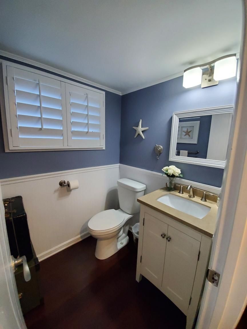 Un bagno con un water, un lavandino e una cassettiera.